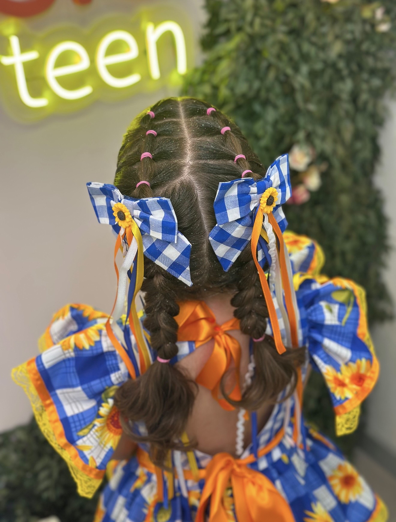 Penteado infantil com tranças, laços e fitas coloridas realizado na Bessie Teen