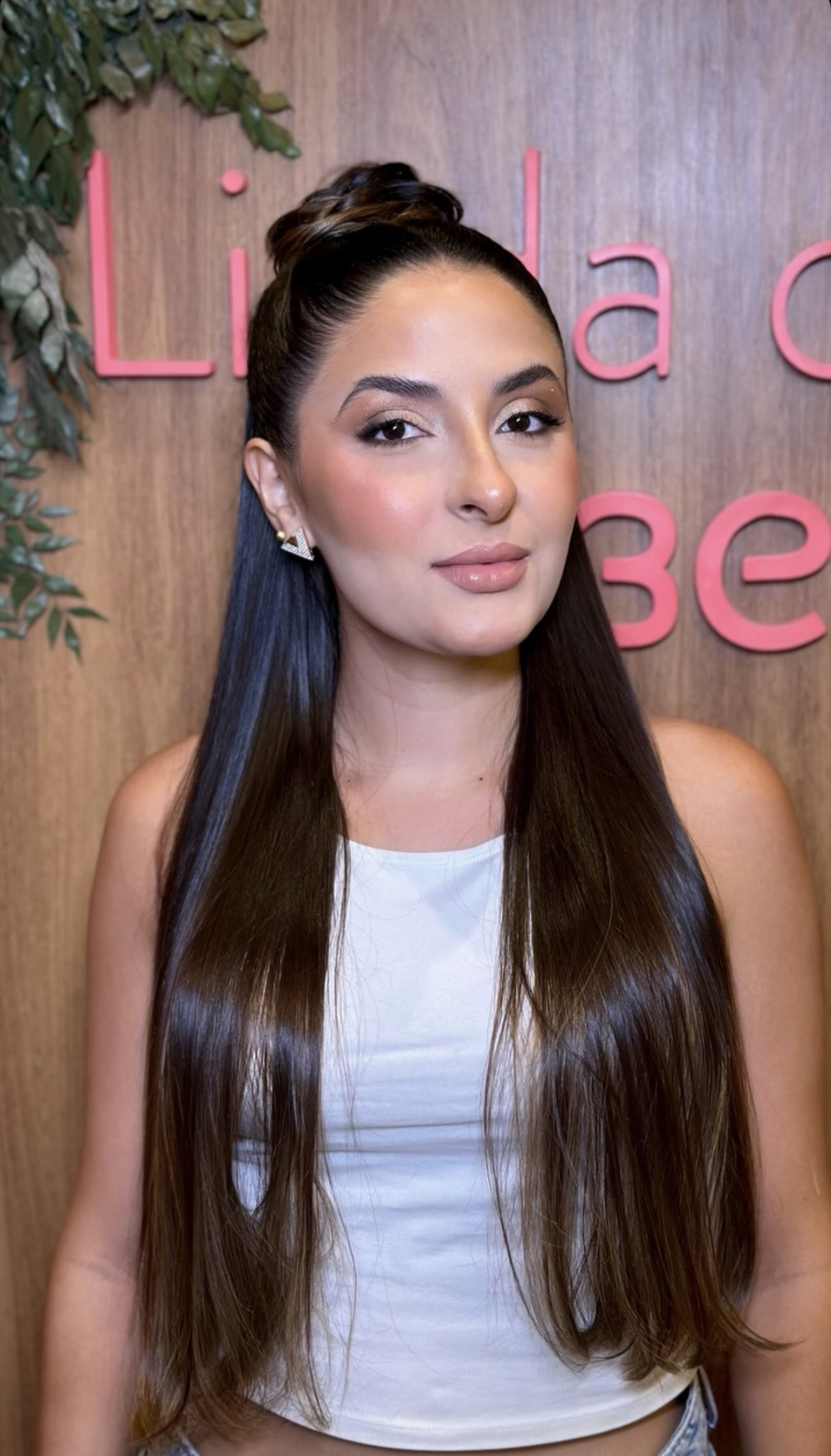 Cliente sorridente com cabelo longo e liso, atendida na Bessie Beauty Club